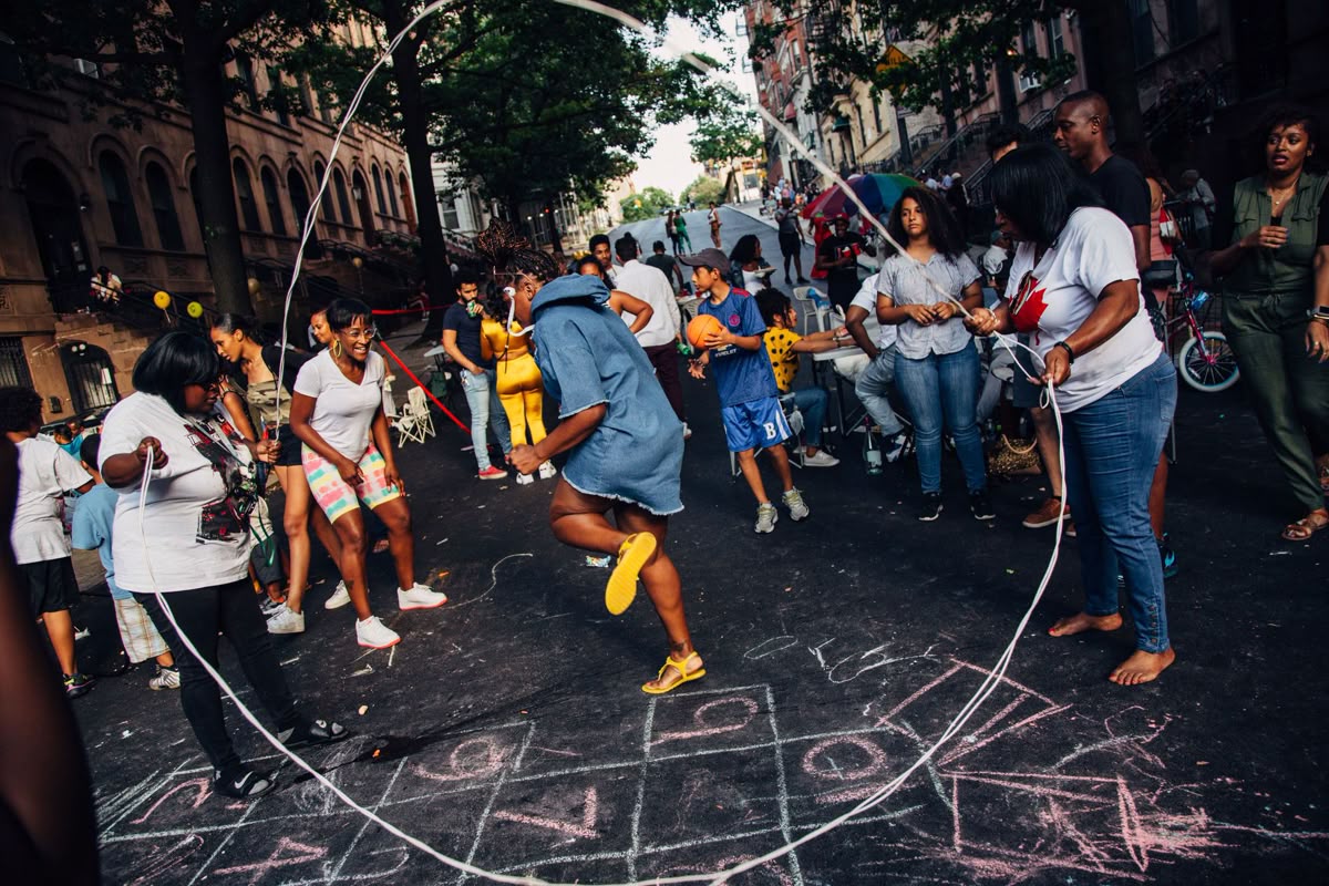 La foto rappresenta quattro ragazze che sorridono con i bicchieri in mano in una scena urban con un muro con graffiti alle loro spalle.